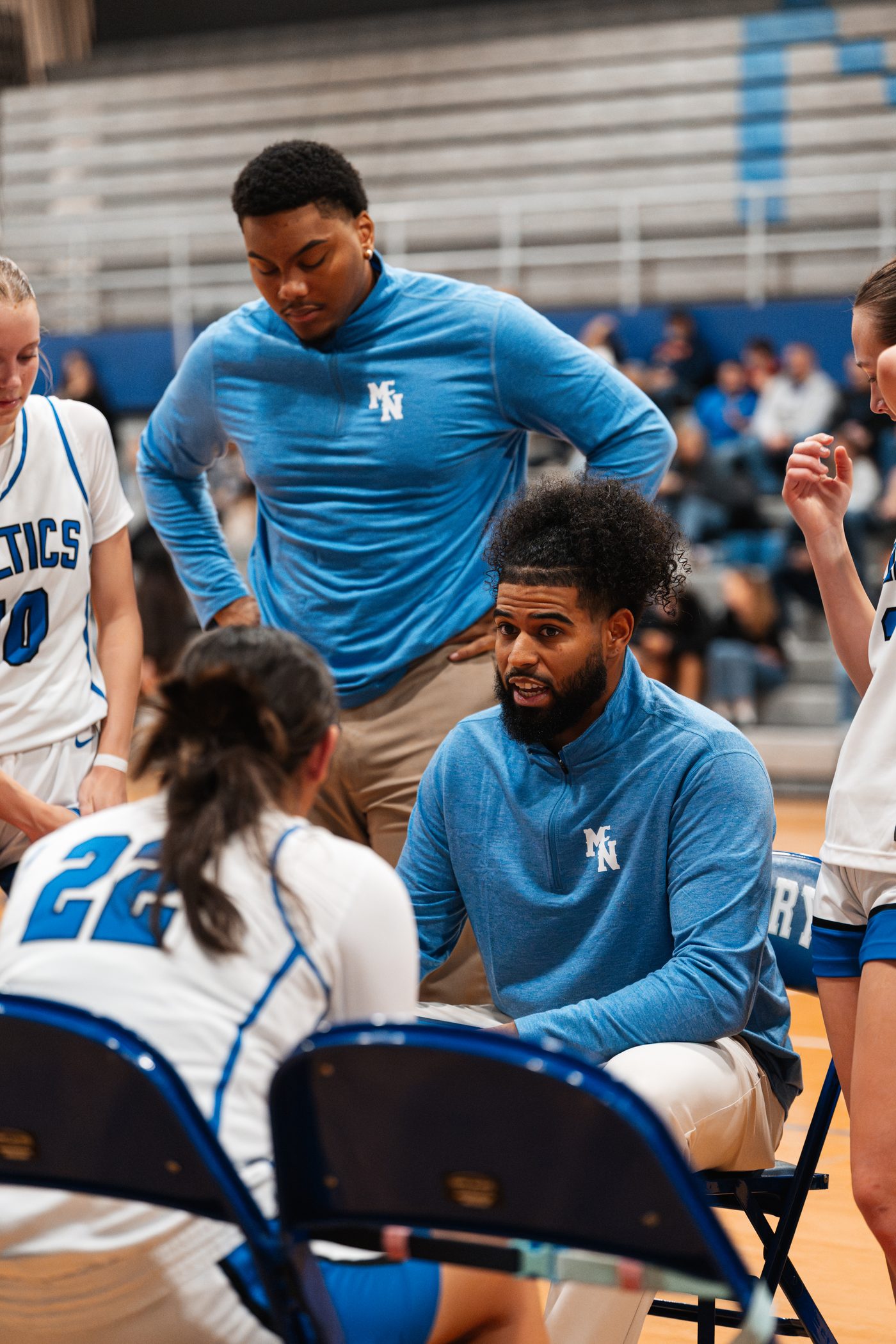 Coach Zay locked in with his team during a huddle